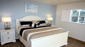 A bedroom with a bed, nightstands, a starfish lamp, a painting, and a window. - Lauras Paradise (Rotonda West)