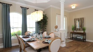 A dining room with a wooden table set for six, surrounded by cushioned chairs. - Blue Pearl (Rotonda West)