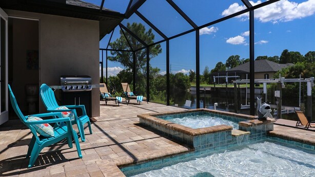 Ein Garten mit Pool, Grill und Liegestühlen.
