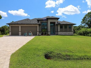 A two-story house with a garage, a front porch, and a well-maintained lawn. - Calypso (Port Charlotte)