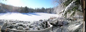 Un espace extérieur enneigé, doté d’une clôture et offrant une vue dégagée sur un champ recouvert de neige.