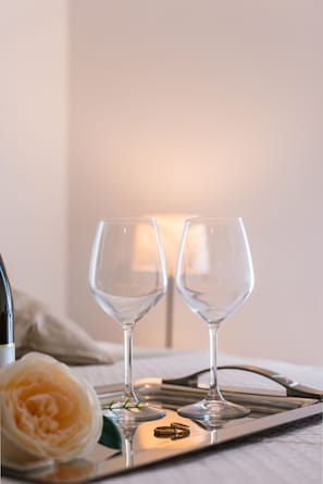 Two empty wine glasses on a tray with a rose and a bottle. - Le Undici Rose Hotel (Viterbo)