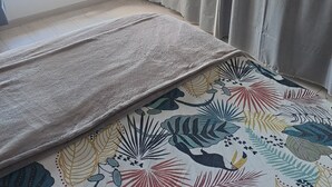 Una stanza con un letto, una finestra e tende.