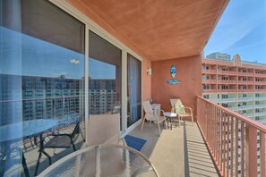Enjoy a room with a balcony offering a view of the city skyline and a seating area.