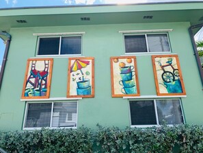 Ein Gebäude mit vier Fenstern, jedes mit farbenfroher Kunst verziert.