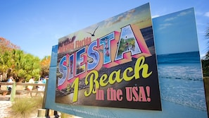 Un panneau sur la plage avec l’inscription « Siesta Beach, aux États-Unis ! » et qui indique que cette plage est classée numéro 1 aux États-Unis, selon Stephen P. Lewis.
