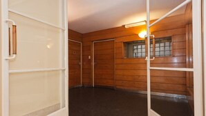 A room with wooden panel walls, a tiled floor, and a window with a view. - Historico Duplex en el Centro (Buenos Aires)
