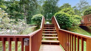 A wooden staircase leading to a bridge in a lush, green park.