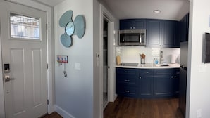 Un espace de vie compact comprenant une cuisine, un coin repas et une chambre.
