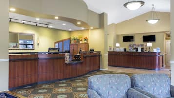A reception area with two counters, a mirror, and a seating area with patterned upholstery.