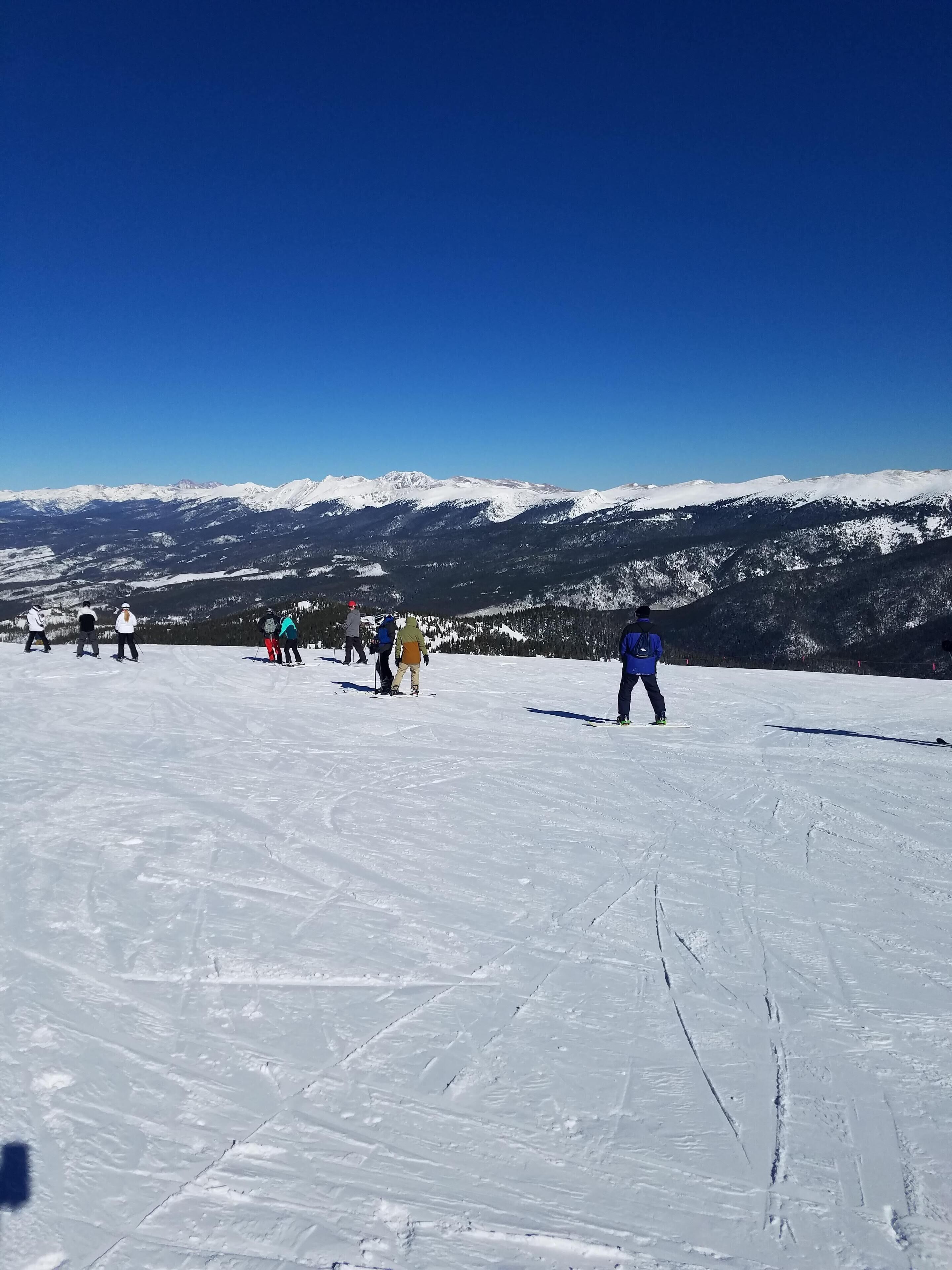 Pista de esquí nevada con esquiadores y snowboarders.