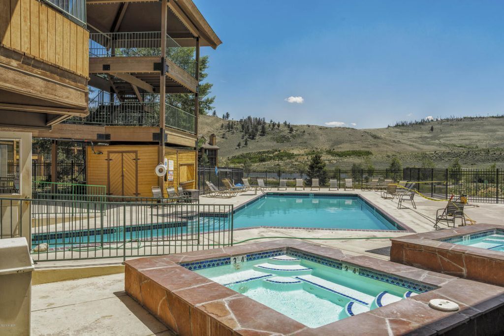 A hotel with a pool area, including a hot tub and lounge chairs.