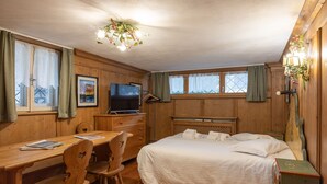 A wooden room with a bed, a desk, and a television. - Faloria Mini (Cortina d´Ampezzo)