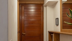 A narrow hallway with a wooden door and a small wooden shelf with a framed picture. - Faloria Mini (Cortina d´Ampezzo)