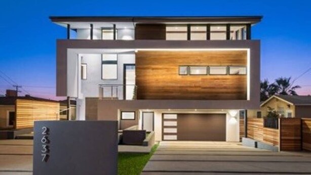 A modern two-story house with a garage, a well-maintained lawn, and a large sign with the number 2637. - New Modern Beach Apartment (Carlsbad)