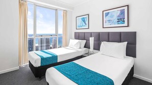 A hotel room with two beds, a large window with curtains, and two framed pictures on the wall. - Chevron Renaissance Ocean View (Surfers Paradise)