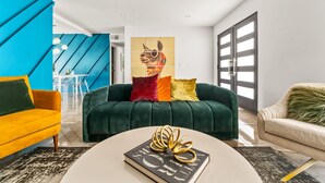 A modern living room with a green sofa, a yellow armchair, and a white coffee table.