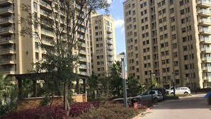Um conjunto de edifícios residenciais com vários prédios altos, um caminho pavimentado e áreas verdes.