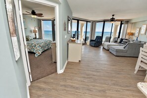A spacious living area with a view of the ocean, a bedroom with a large bed, and a dining area with a table and chairs. - One Ocean Place 605 - Oceanfront in Garden City Beach (Garden City)