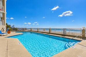 A clear blue pool with a view of the beach, a lifeguard chair, and a sign indicating a 3ft depth. - One Ocean Place 605 - Oceanfront in Garden City Beach (Garden City)