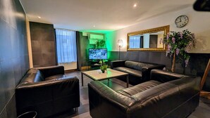 Una sala de estar moderna con un sofá de cuero, una mesa de centro y un televisor de pantalla plana.