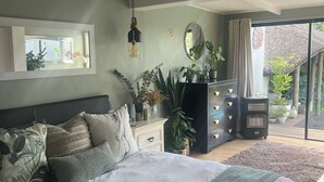 Una camera da letto con un letto grande, una ventola a soffitto, un comò e vista sull'esterno.
