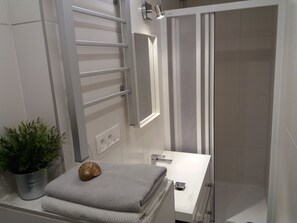 Regadera, secadora de cabello, toallas, papel de baño 