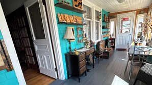 A cozy interior with a teal accent wall, wooden flooring, and a glass table. - Heritage Classic Inn B&B - Room 1 (Hunter River)