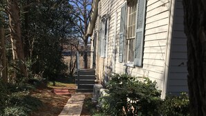 Un chemin menant à une maison avec une entrée en briques et un petit porche.