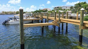 A wooden dock extending into calm water with boats moored at the end. - Waterfront 3-Bedroom Condo at Bayfront Suites & Marina- CLEANING FEE INCLUDED (Key West)