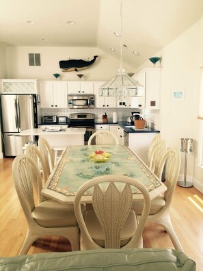 Enjoy meals in the kitchen with a dining area for six, featuring a chandelier and decorative wall hanging.
