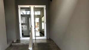 Un pasillo con una puerta de cristal que da a una zona de estacionamiento.