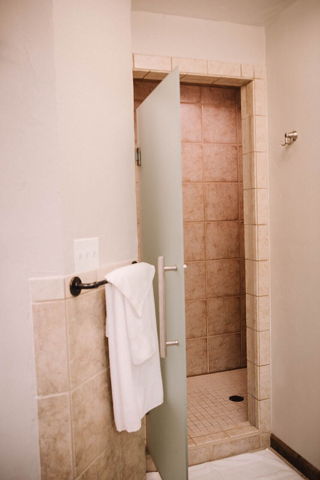 A bathroom with a shower stall and a towel rack.