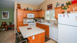 Une cuisine avec des meubles en bois, un four blanc, un four à micro-ondes et un réfrigérateur.