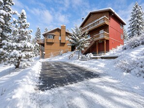 A two-story lodge with a red exterior and a brown roof, surrounded by snow-covered trees. - Ben's Cool Cabin - Forest Views, Smart TV, Deck, BBQ (Big Bear Lake)