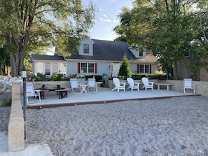 Un patio con mobiliario exterior, una mesa de picnic y un pequeño jardín.
