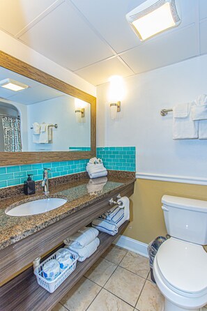 A bathroom with two sinks, a mirror, a toilet, and a trash can. - Over-sized Luxury Balcony with teak loungers! Modern Style in the Golden Mile (Myrtle Beach)