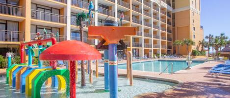 Ein Hotel mit Poolbereich, bunten Wasserspielgeräten und einem großzügigen Gebäude mit Balkonen.