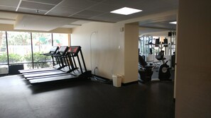 A gym with treadmills, a stationary bike, and a weight machine. - Over-sized Luxury Balcony with teak loungers! Modern Style in the Golden Mile (Myrtle Beach)