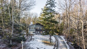 A house surrounded by trees with a snow-covered driveway. - Killington Chalet - Great Space and Location! (Killington)