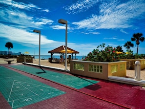 A shuffleboard court with a view of the beach and a gazebo.