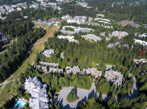 Vista aérea de una zona residencial con varias casas, rodeada de un bosque denso.