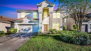 A two-story house with a central entrance, a garage, and a well-maintained lawn.