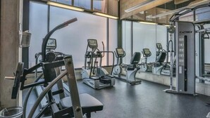 Een sportschool met diverse fitnessapparaten, grote ramen en een modern design.