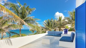 A terrace with white walls, blue accents, and a view of the ocean. - Luxury Ocean Front Villa,  6BR (12 pax) Breakfast includes + infinity pool (Isla Mujeres)