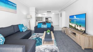 A modern living room with a sofa, coffee table, and TV.