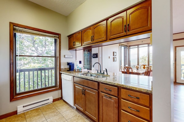 Kitchen features a dishwasher and adjacent dining area with a table and chairs.