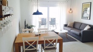 Ett modernt vardagsrum med en matplats, en soffa och ett matbord med stolar.