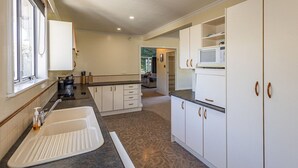 A kitchen with a sink, cabinets, and a microwave.