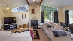 A living room with a stone fireplace, a television, and a sofa.